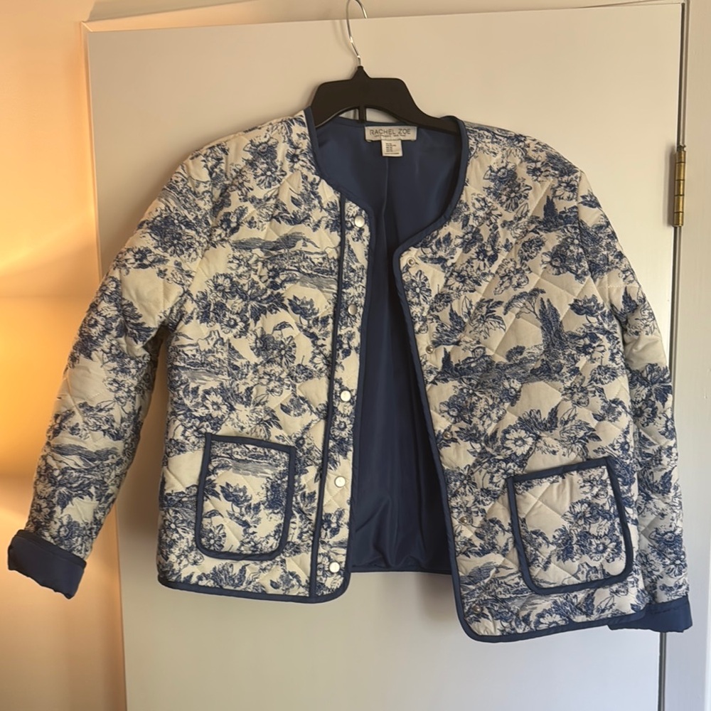 Classic blue toile quilted jacket with two patch pockets and a snap front.